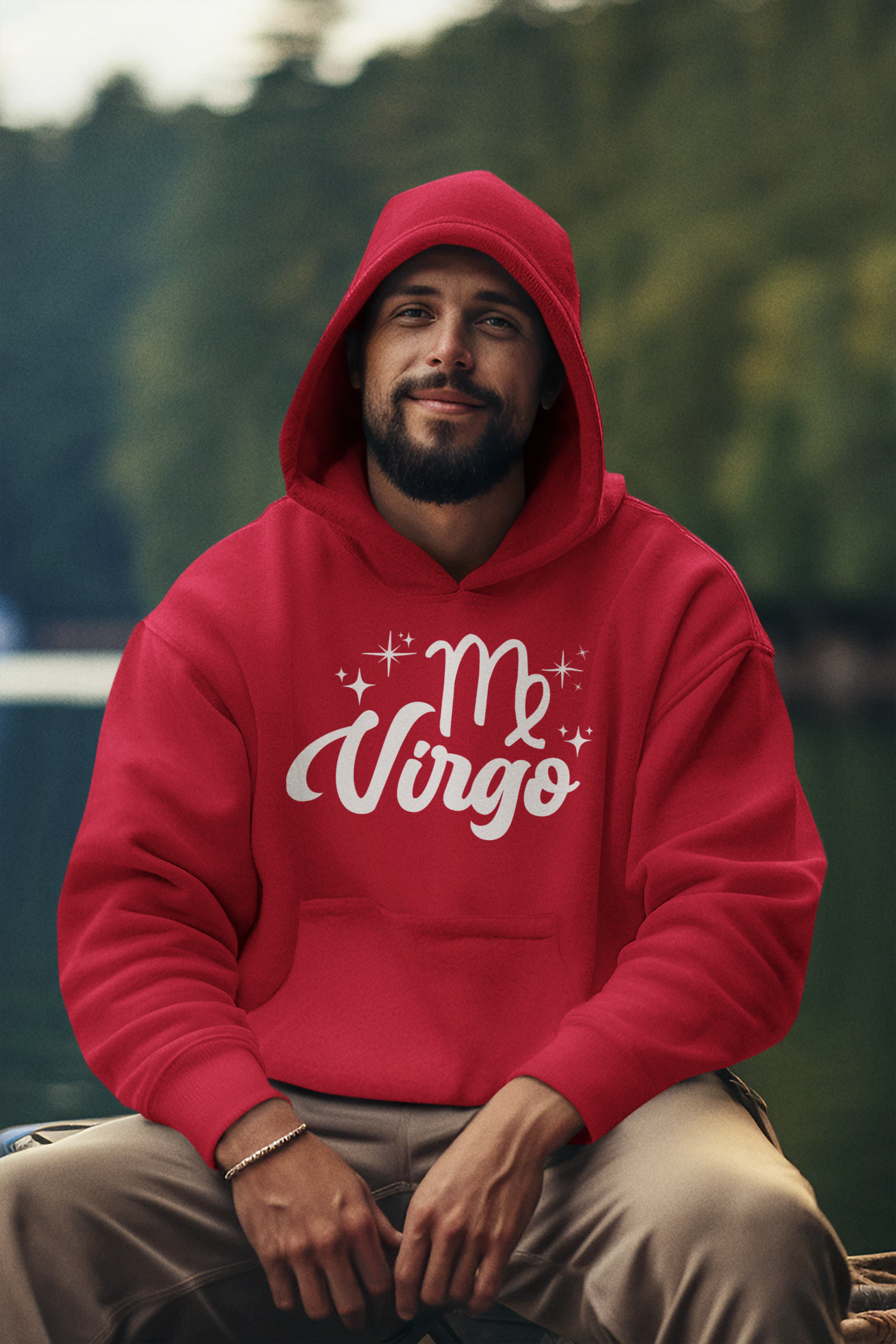 Man wearing a red hoodie with 'Virgo' white text design, sitting outdoors with a blurred natural background