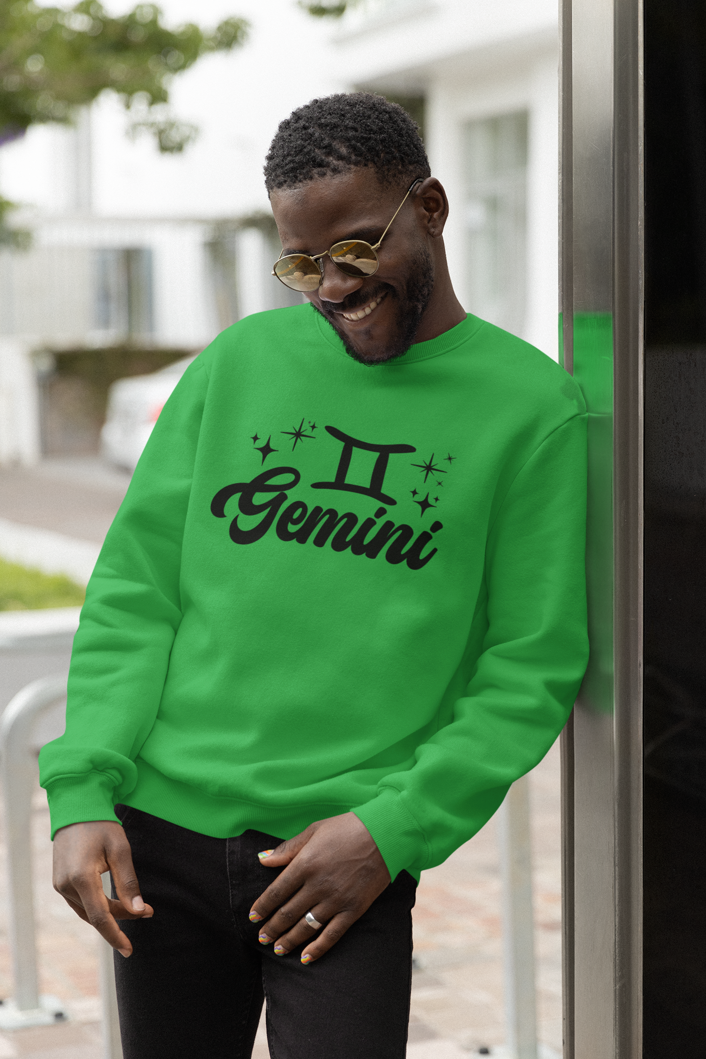 Person wearing a green 'Gemini' black text design sweatshirt with zodiac symbol outdoors.