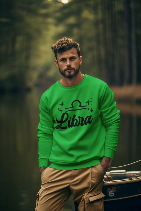 Man wearing a green 'Libra' black text design sweatshirt in a lake setting