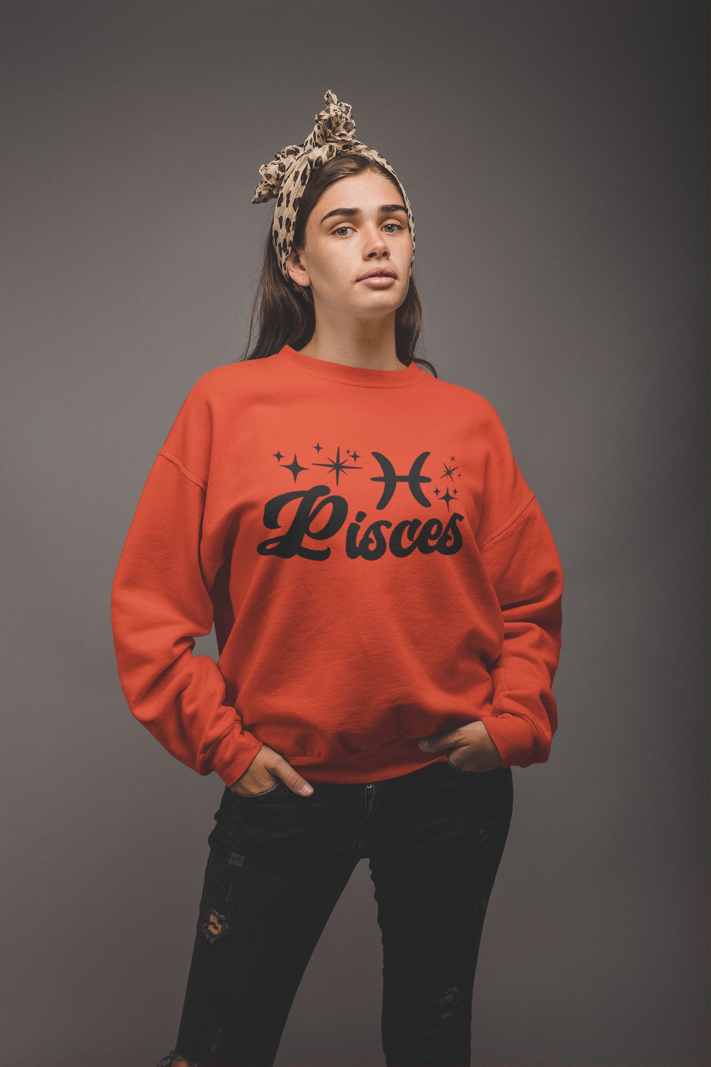 Person wearing a orange 'Pisces' black text design sweatshirt on a gray background