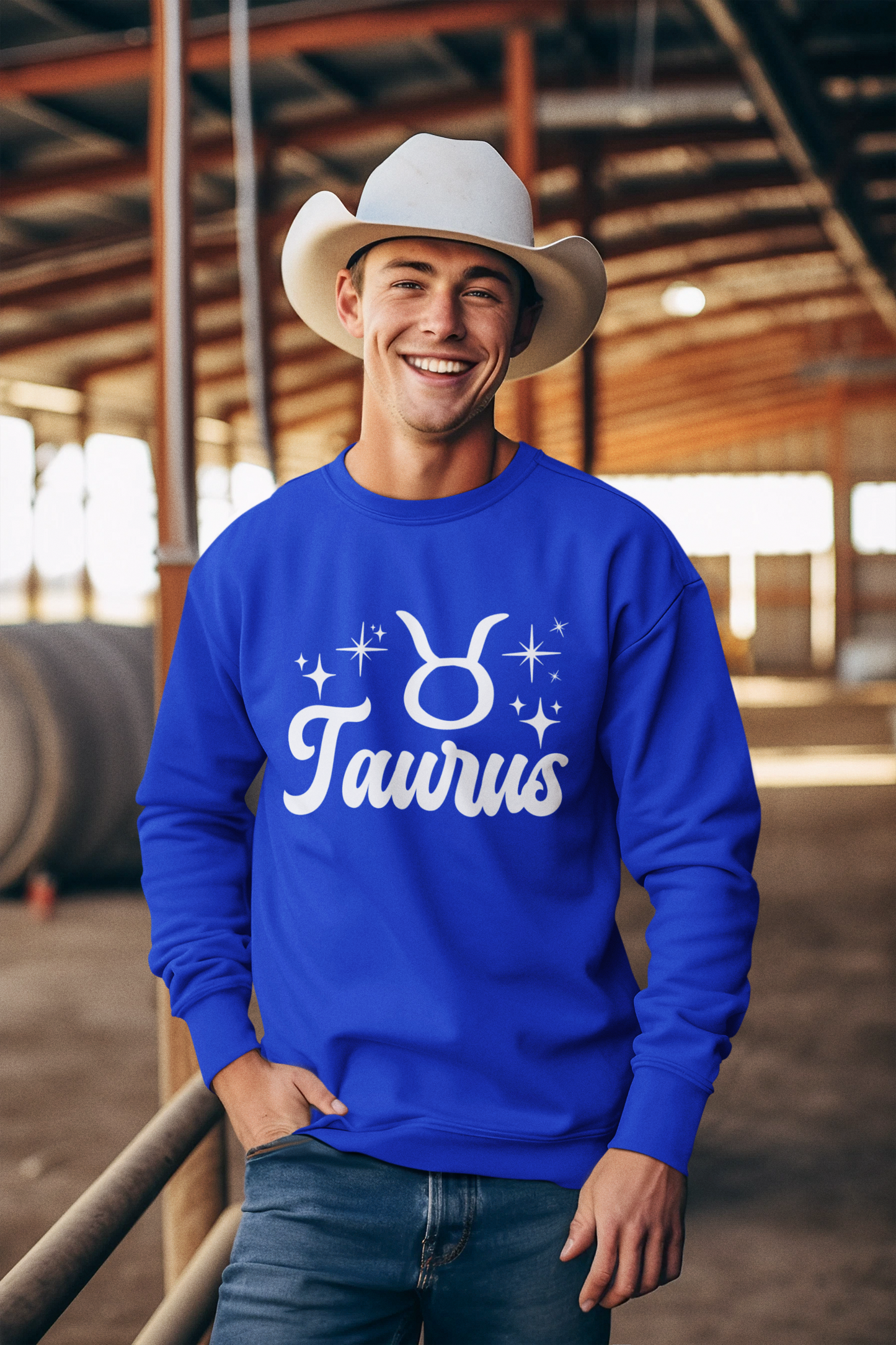 Man wearing a blue 'Taurus' white text design sweatshirt in an barn setting