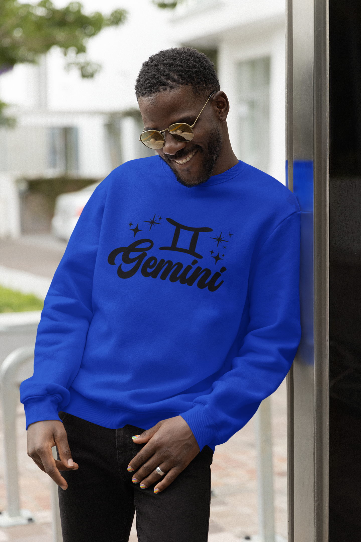 Person wearing a blue 'Gemini' black text design sweatshirt with zodiac symbol outdoors.