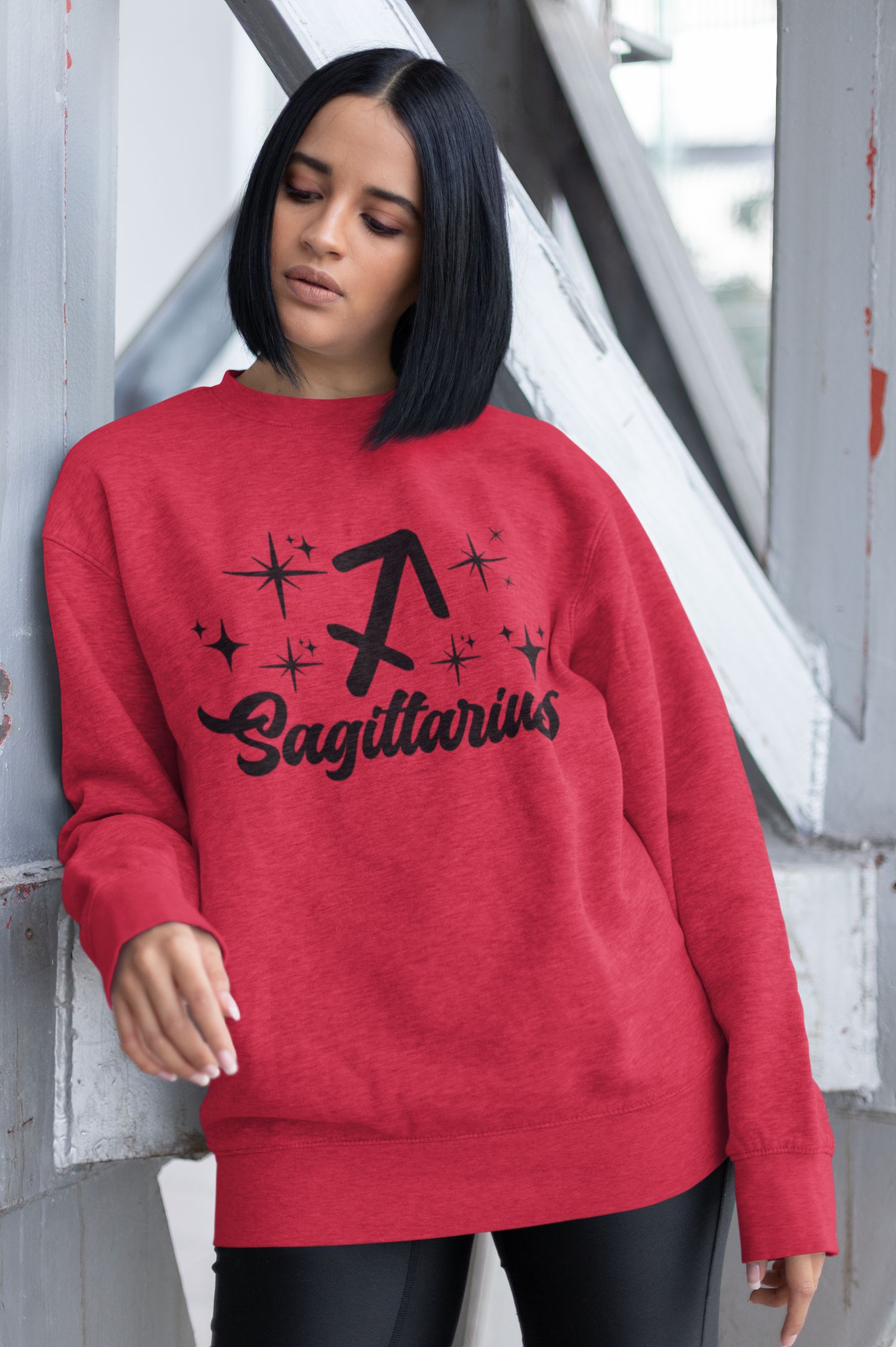 Person wearing a red sweatshirt with 'Sagittarius' black text design outdoors.
