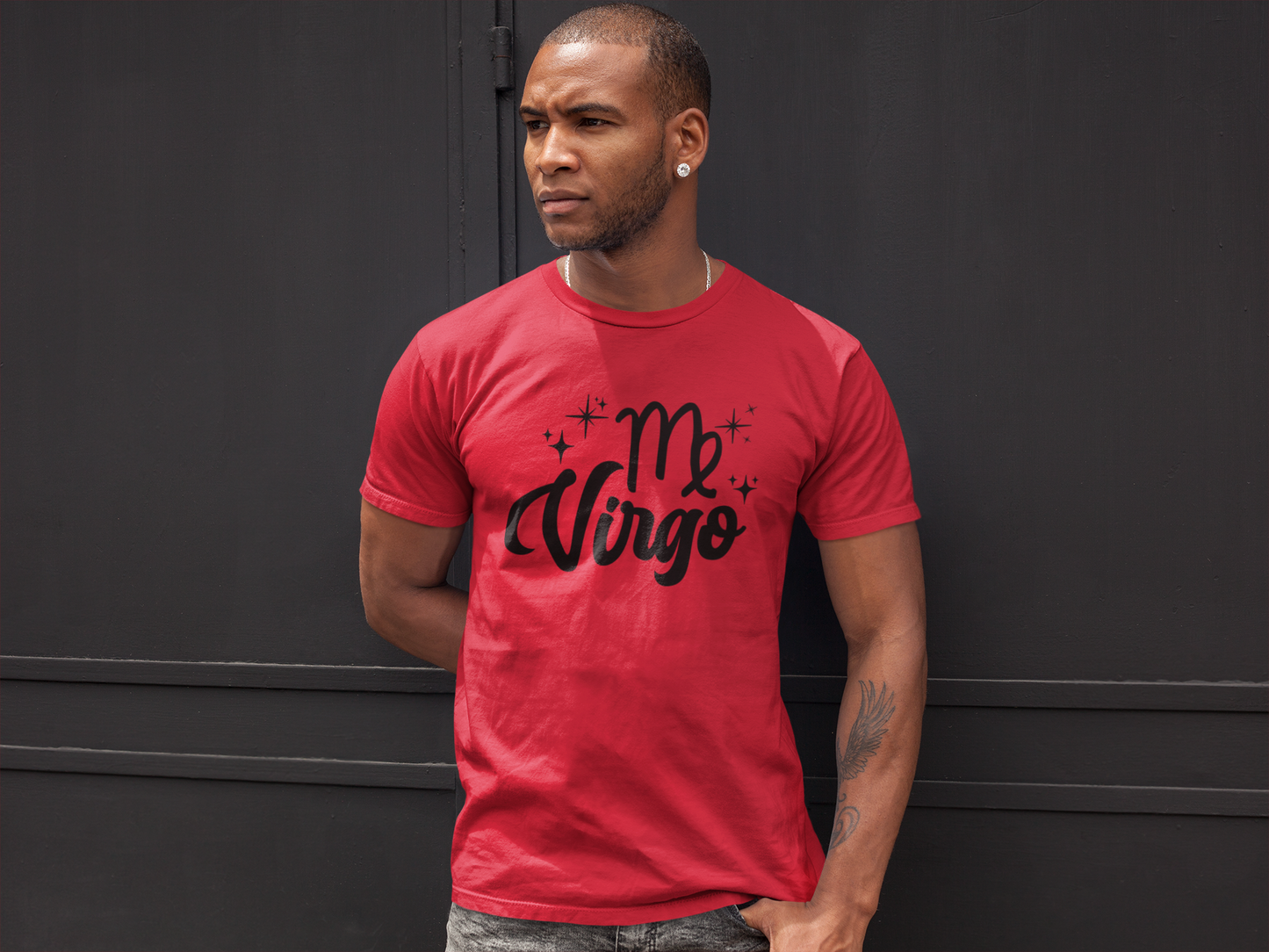 Man wearing a red t-shirt with 'Virgo' black text against a black wall background