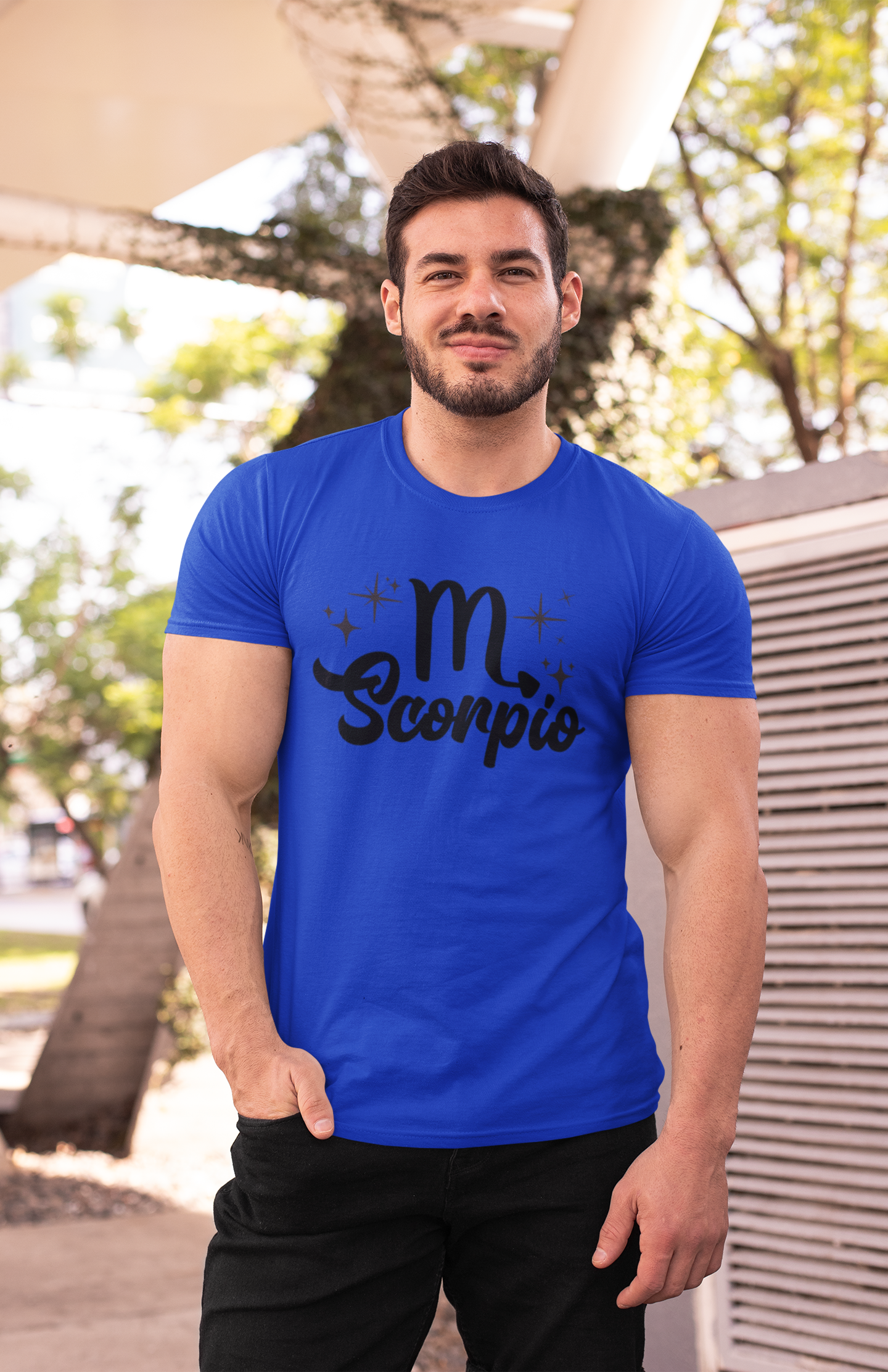Man wearing an blue t-shirt with 'Scorpio' black text design outdoors.
