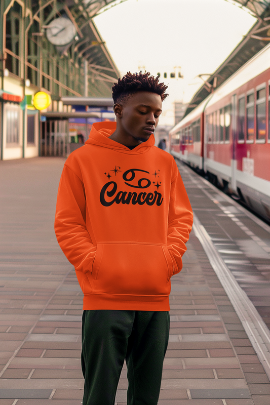 Person wearing an orange hoodie with 'Leo Cancer' black text at a train station.