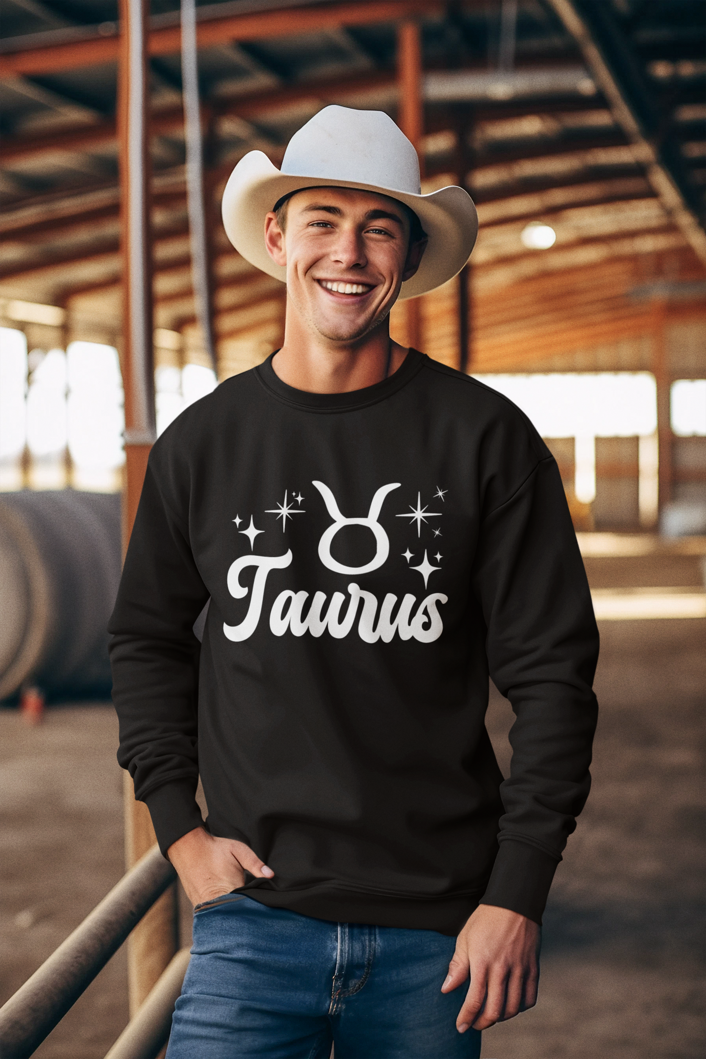 Man wearing a black 'Taurus' white text design sweatshirt in an barn setting