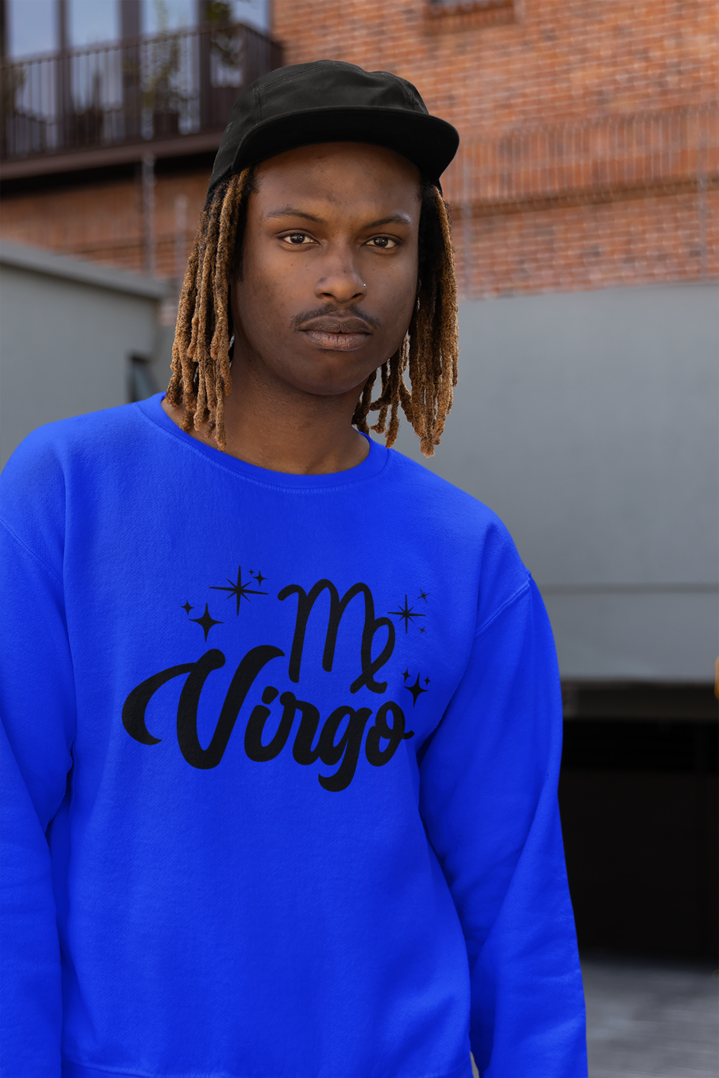 Person wearing an blue sweatshirt with 'Virgo' black text design, standing outdoors.