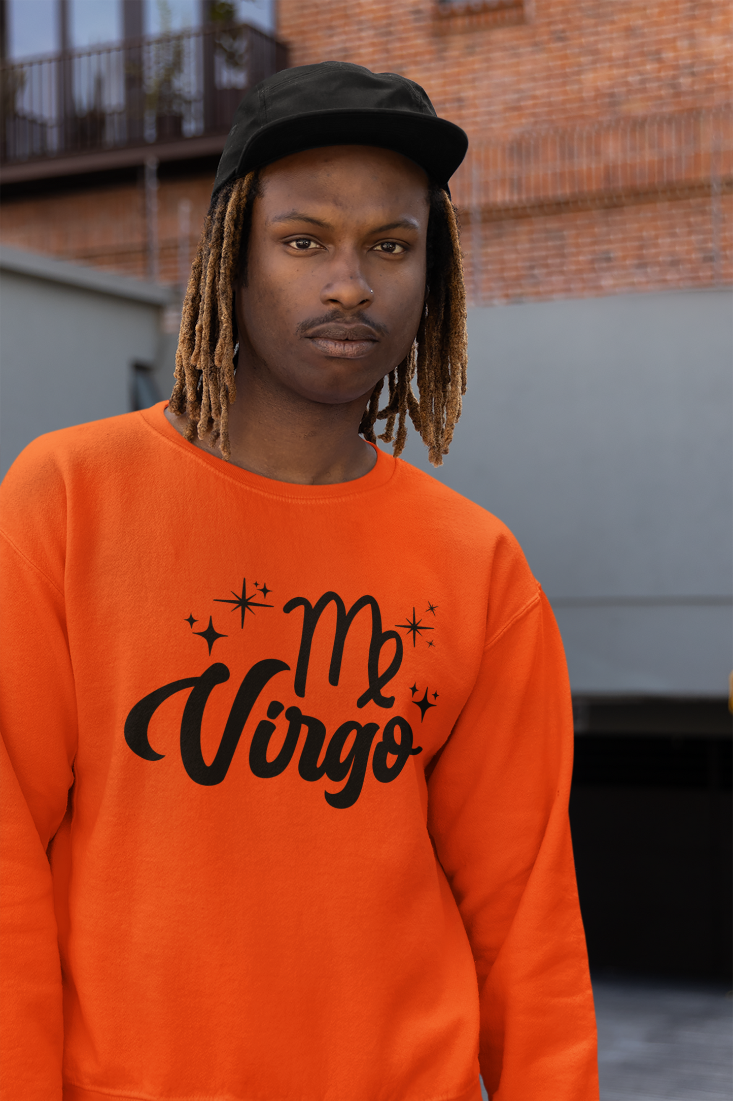Person wearing an orange sweatshirt with 'Virgo' black text design, standing outdoors.