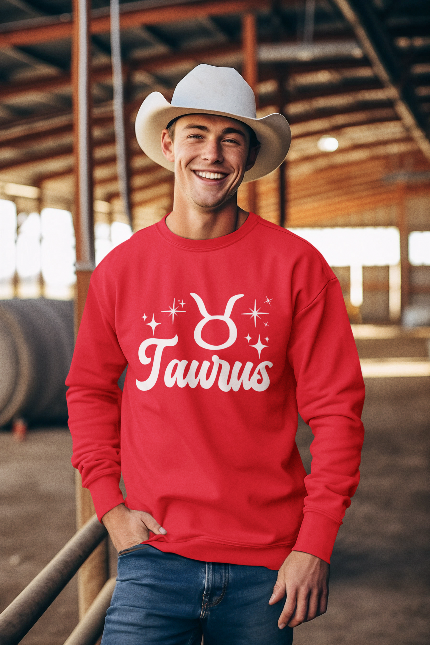 Man wearing a red 'Taurus' white text design sweatshirt in an barn setting