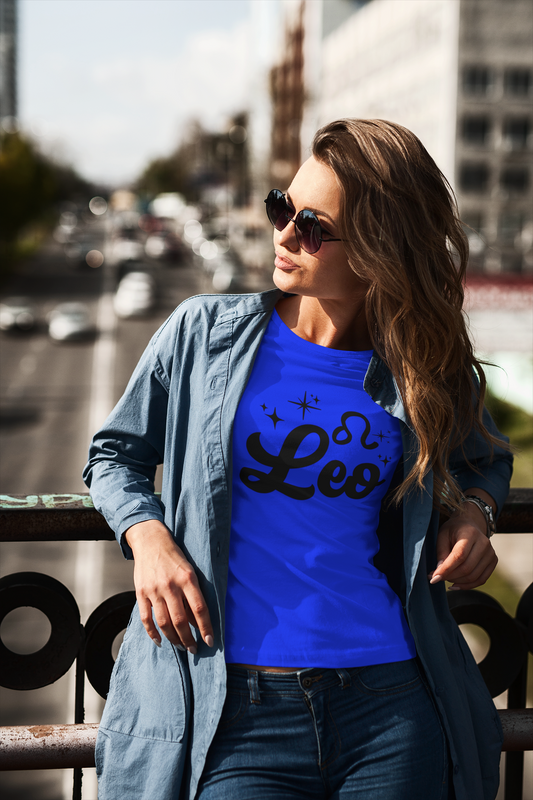 Woman wearing a blue t-shirt with 'Leo' black text design standing on a overpass.