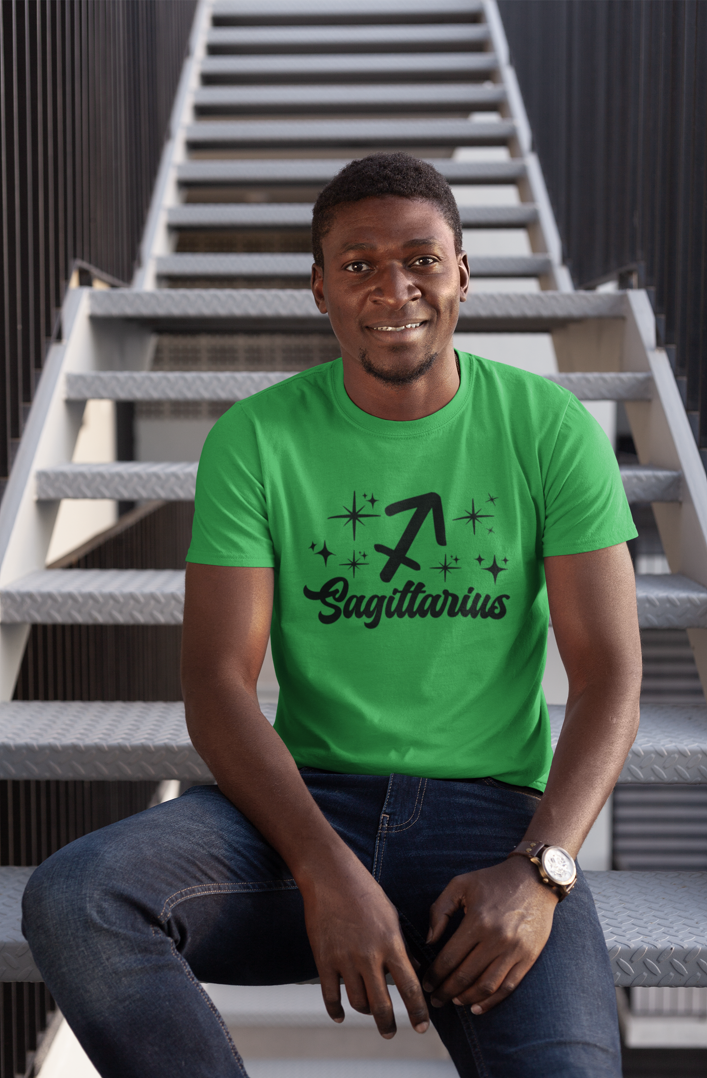 Man wearing a green t-shirt with 'Sagittarius' black text design sitting on stairs.