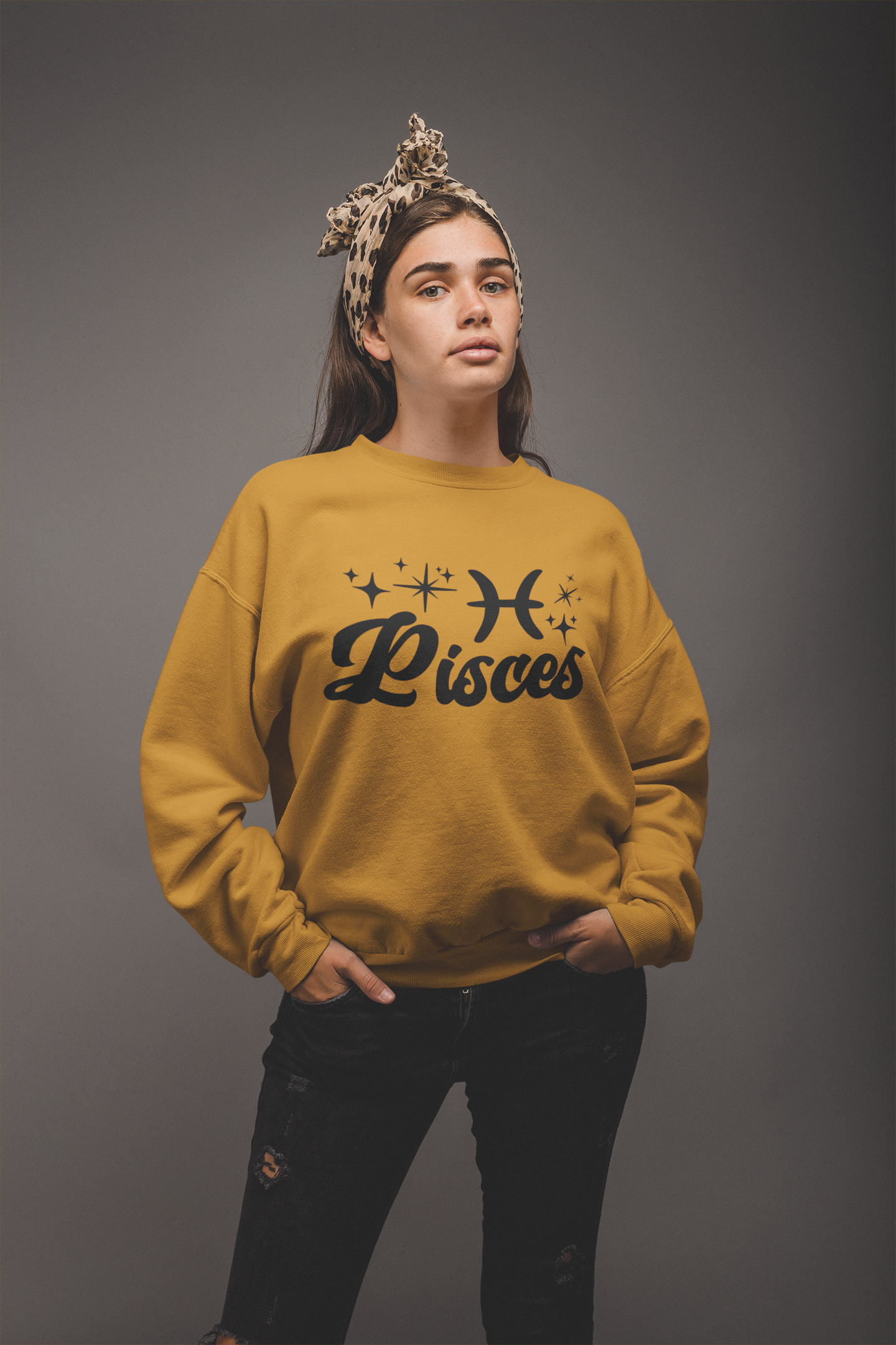 Person wearing a gold 'Pisces' black text design sweatshirt on a gray background