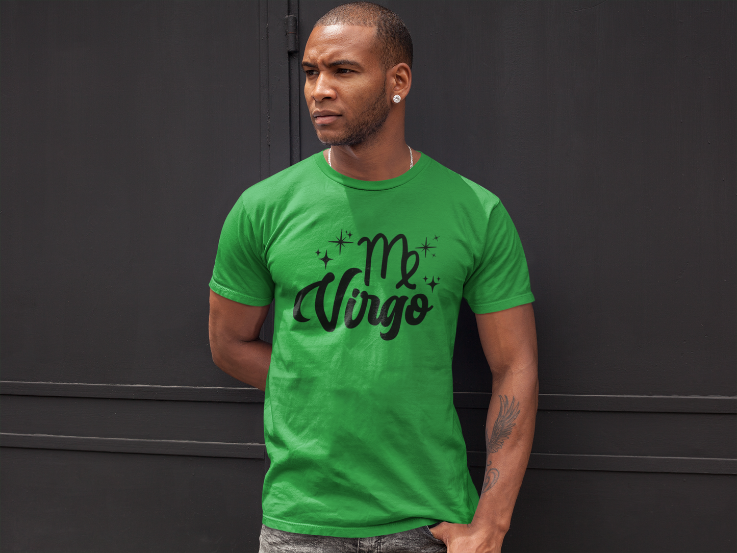 Man wearing a green t-shirt with 'Virgo' black text against a black wall background