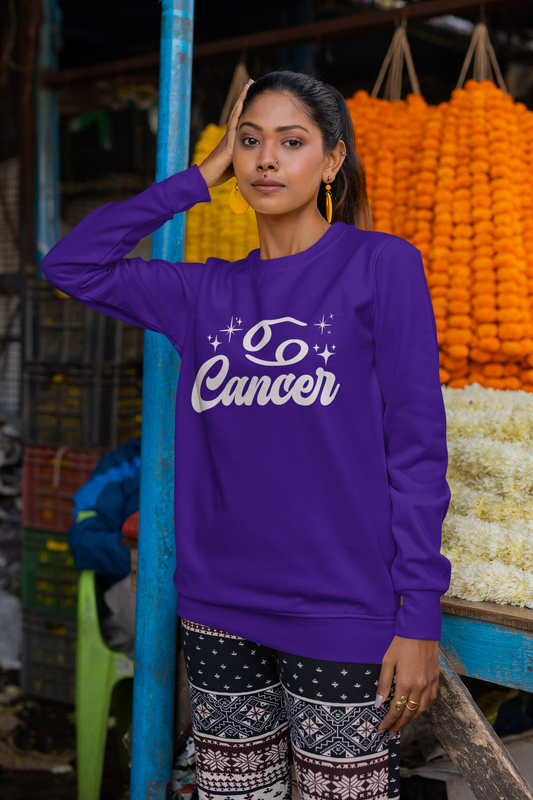 Woman wearing a purple sweatshirt with 'Cancer' white text in an outdoor market setting